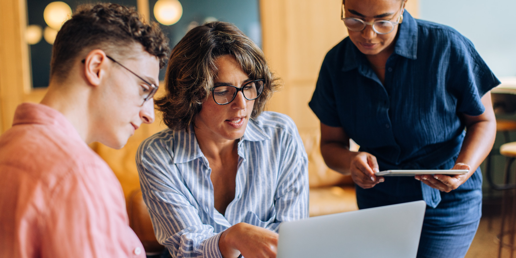 Team bespricht Arbeit auf einem Laptop